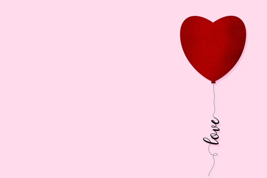 Red heart shape balloon and the string with the word love on pink background, copy space available. Valentine concept.
