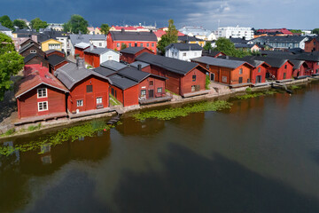 Fototapeta na wymiar View of the old red barns (symbol of the city of Porvoo) on the bank of the Porvoonjoki river on a July afternoon. Porvoo, Finland