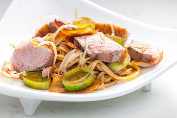slices of duck breast with noodles, vegetables and bamboo shoots