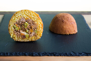 Arancini are a specialty of Sicilian cuisine. They are stuffed breaded and fried rice balls or cones.