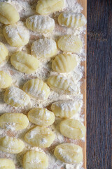 Balkan cuisine. Njoke from potato ( potato gnocchi, dumpling ) on wooden cutting board. Rustic background. Copy space