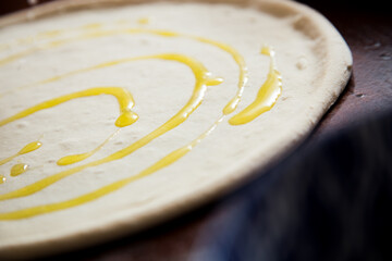 Preparing the dough for a Neapolitan pizza with tomato and cheese.