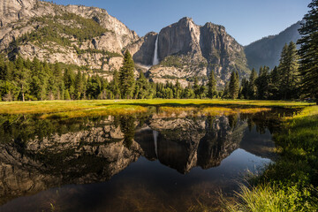 View of Sentinel Falls in Yosemite valley and lake reflections