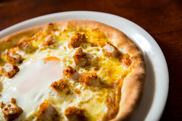 Pizza with breaded pork, curry and egg. Neapolitan pizza made with mozzarella. Italian recipe.