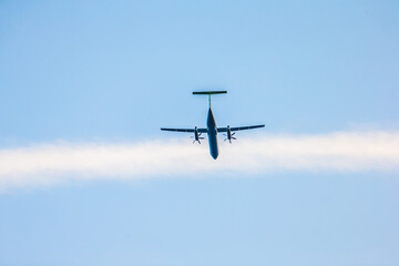 Propeller airplane lifting off from below