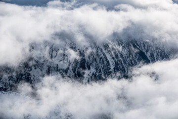 Mountains visible through clouds from a far in Austrian Alps