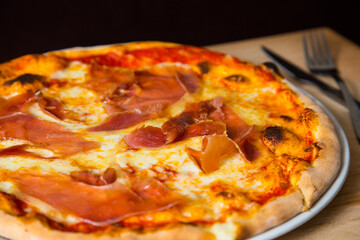 Serrano ham pizza. Neapolitan pizza made with baked vegetables and serrano ham. Italian recipe.
