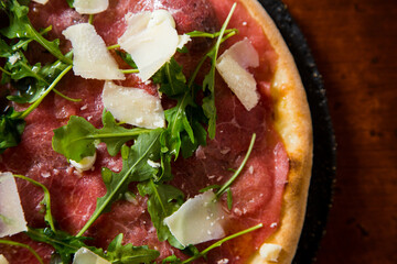 Pizza beef carpaccio. Neapolitan pizza made with tomato sauce, cheese and beef. Italian recipe.