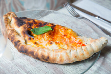 Calzone Pizza. Neapolitan pizza stuffed with cheese, tomato and other ingredients such as meat or...