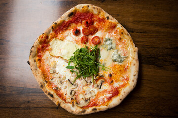 Four Seasons Pizza. Neapolitan pizza with tomato sauce, cheese, ham, mushrooms and vegetables. Authentic Italian recipe.