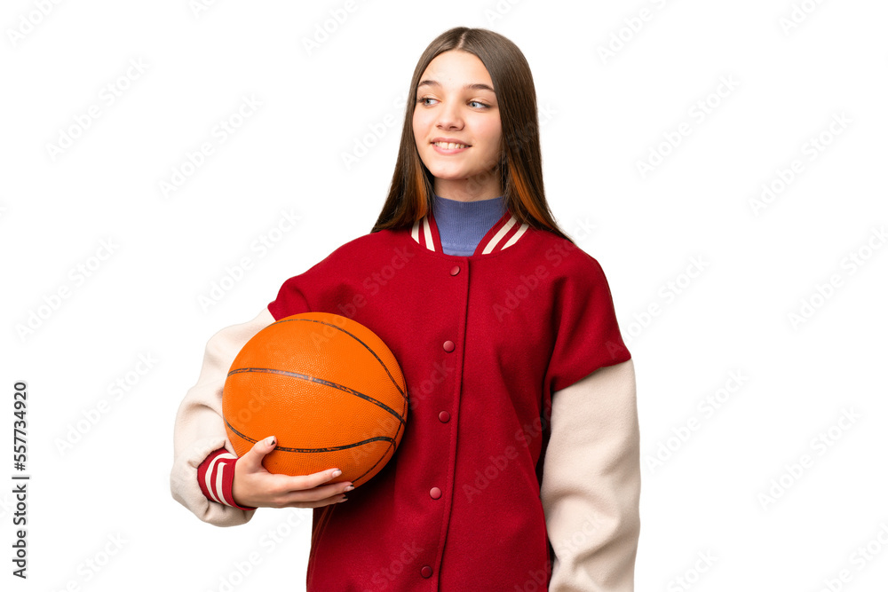 Wall mural Teenager girl playing basketball over isolated chroma key background looking to the side and smiling