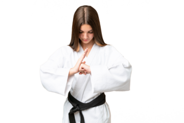 Teenager girl over isolated chroma key background doing karate and saluting