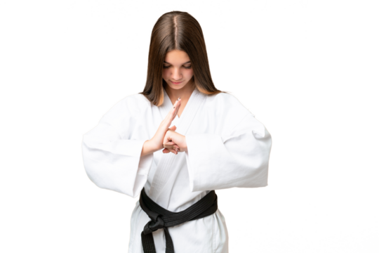 Teenager girl over isolated chroma key background doing karate and saluting