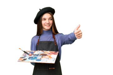 Young artist man holding a palette over isolated chroma key background giving a thumbs up gesture