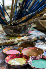 Close up acrylic paint from a palette full of many colored spots.