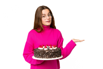 Teenager girl holding birthday cake over isolated chroma key background extending hands to the side for inviting to come