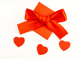 Gift red box and a bow with red hearts on a white background. Holiday concept. Valentine's Day.