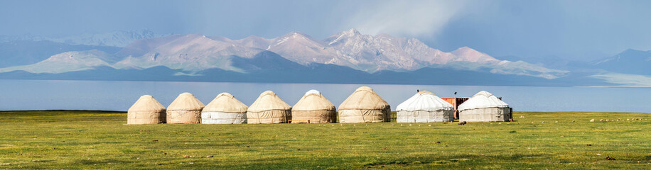 Traditional Yurt tent camp at the Song Kul lake plateau in Kyrgyzstan. Yurt tents are traditional, portable tents made of felt that are used as a form of accommodation in the country. - obrazy, fototapety, plakaty