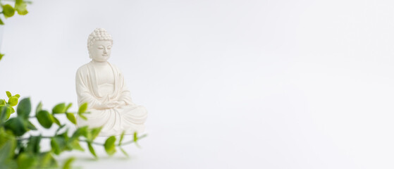 Vesak Day is holy day for Buddhists. Happy Buddha Day with Siddhartha Gautama statue on white background. Mental health and meditation concept. Selective soft focus.