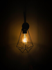 Close up vintage lamp. Antique incandescent light bulb illuminates on dark background