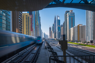 Fototapeta na wymiar Dubai metro train entering the station with background of high rise building in Dubai downtown.