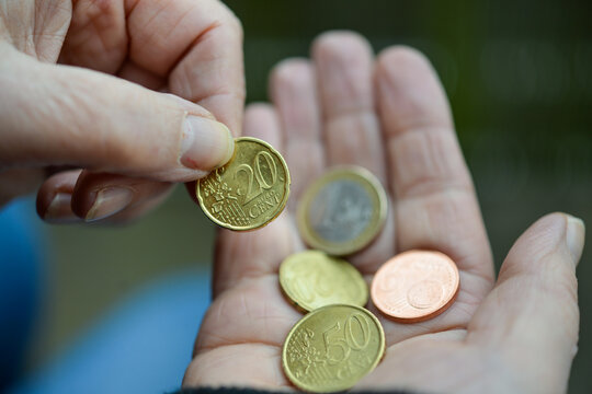 Konzept Armut: Ältere Frau mit schmutzigen Fingernägeln zählt einige Euromünzen in der Hand – selektive Schärfe