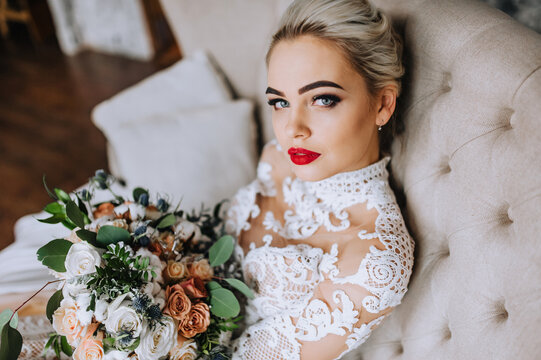 Close-up portrait of a beautiful blonde bride in a white lace dress with a bouquet of flowers. wedding photography.