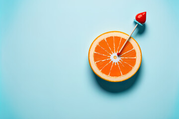 On a light blue backdrop, an orange fruit with a red dart and a circle target is shown. Concept of minimum food and fruit. An innovative concept for creating work for an advertising, marketing, or com