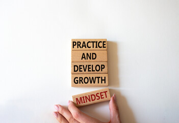 Practice and Develop growth mindset symbol. Wooden blocks with words Practice and Develop growth mindset. Businessman hand. Beautiful white background. Business concept. Copy space