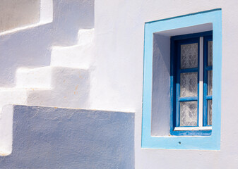A famous blue painted window of the Greek Islands- Santorini. A vibrant frame looks at the...