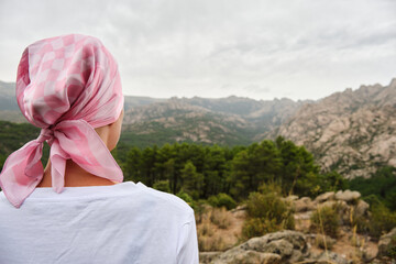 Woman with cancer meditating on her illness in nature.