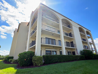 Condo complex near Tampa Florida with balconies and glass sliding doors with blue sky background