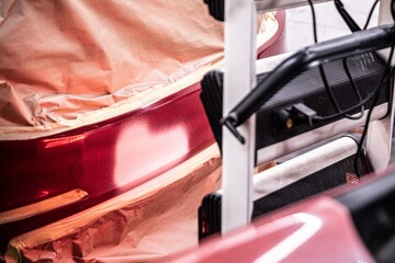 Naklejka premium Ir curing the basecoat on the bumper of a red car after paint repair