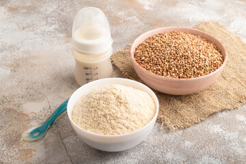 Powdered milk and buckwheat baby food mix, on brown concrete, side view