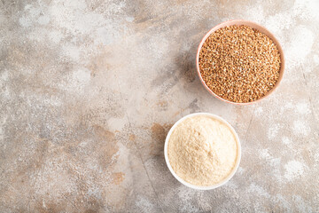 Powdered milk and buckwheat baby food mix, on brown concrete, top view, copy space