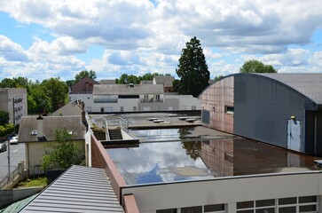 Rooftop view: slate roofs, metal siding roofs, flat roof with water, houses, building, little...
