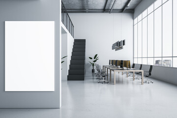 Fototapeta premium Front view on blank white poster on light grey wall in spacious coworking office with wooden table, light floor, dark stairway and city view background from window. 3D rendering, mock up
