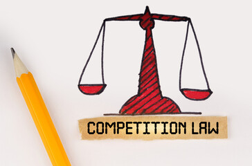Next to the painted scales of justice lies a pencil and a strip of paper with the inscription -...