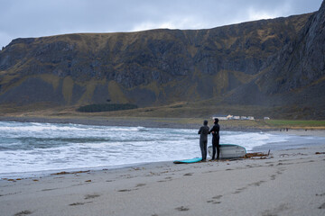 Surfers at Unstad Beach in Lofoten Islands, Norway