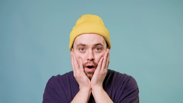 portrait of handsome guy shocked Emotional surprised young man looking at camera, shocked surprised stupefied young brunet man 25s years old looking camera say wow omg mouth wide open hands on face