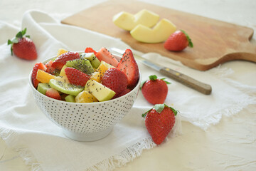 Bowl of fresh fruit salad, kiwi, apples, oranges