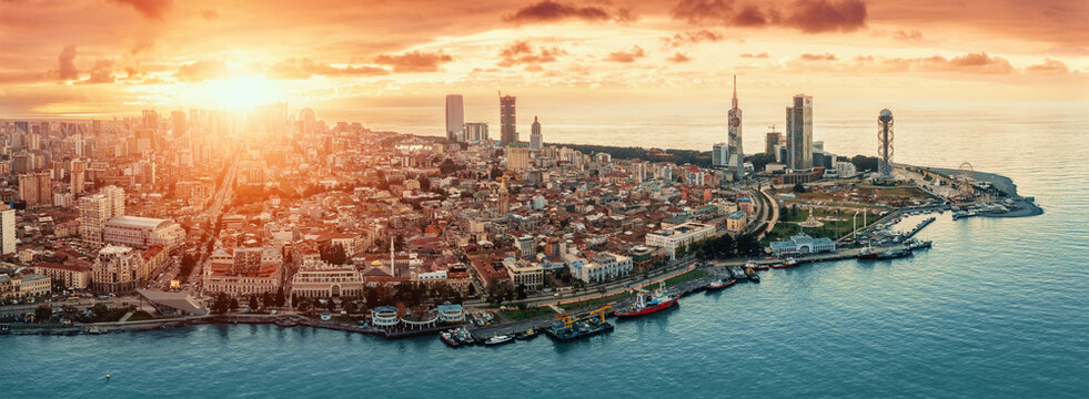 Batumi at sunset, Adjara, Georgia. Aerial panorama view from drone with modern buildings on seafront promenade. Beautiful resort town on Black Sea.