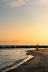 Woman walking on the beach during sunset