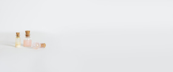 Miniature glass flasks with colored liquids on bedlm background .Isolated White background. Horizontal banner Space for text on the right 