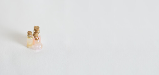 Miniature glass flasks with colored liquids on bedlm background .Isolated White background. Horizontal banner Space for text on the right