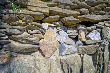 The texture of the masonry wall of natural stone. Detail of a stone wall with different size of rocks.
