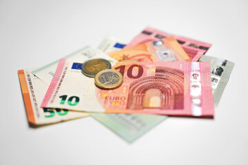 Pile of Euro bills coins  in detail on white