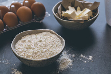 Flour, butter and eggs on the kitchen table, close-up.