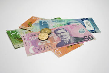 Pile of New Zealand dollars and  coins  in detail on white