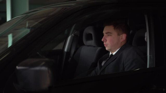 A solid man in a suit yawns and falls asleep